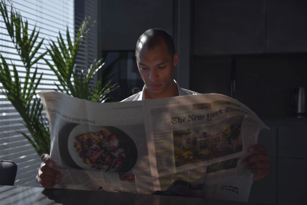 Businessman focused on reading newspaper in a sunny indoor office setting. — Choosing Between Wire Bound and Other Book Print