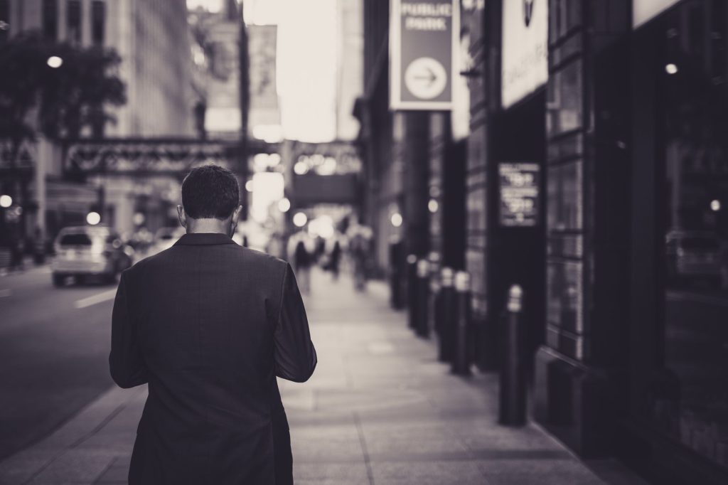 Man in a suit walking down a city street in a lonely, urban setting. — Exploring Fixed-Term Deposit Options for Short-Term an