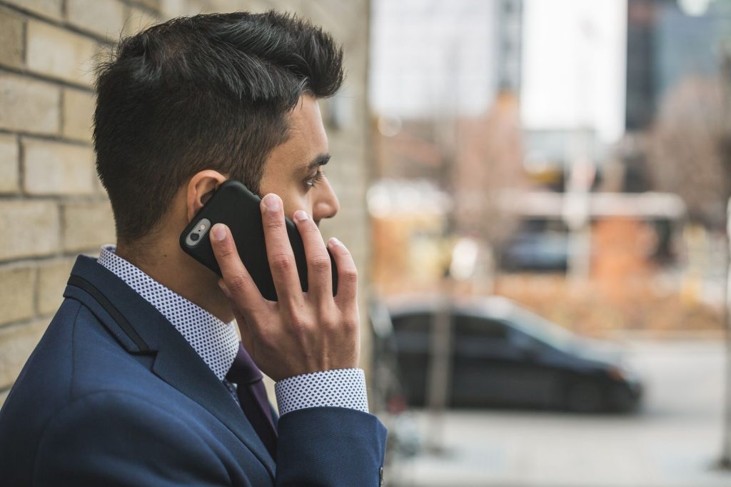 Professional man in suit making a phone call outside in city setting. — The Beauty of Wooden Loft Ladders: Aesthetic Appeal
