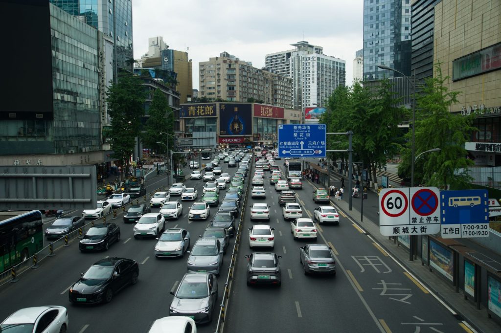 Heavy traffic on a busy Shanghai street lined with skyscrapers and billboards during the day. — The Future of Decentralized F